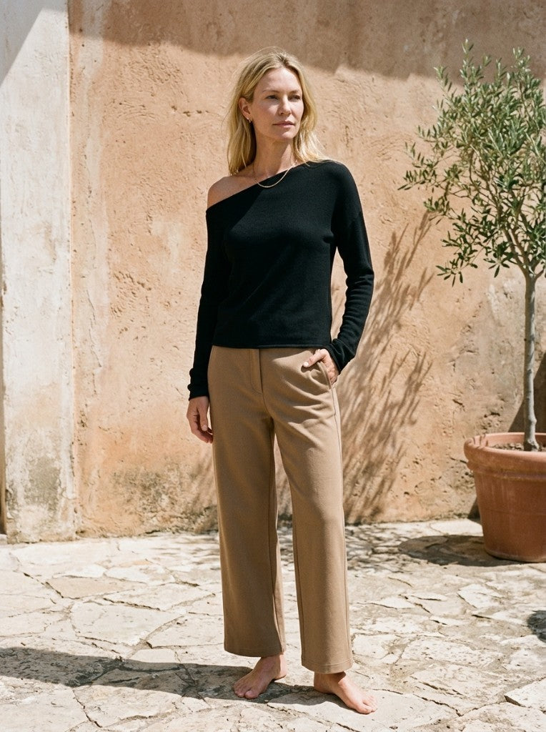 Woman wearing the black off-shoulder top with taupe pants