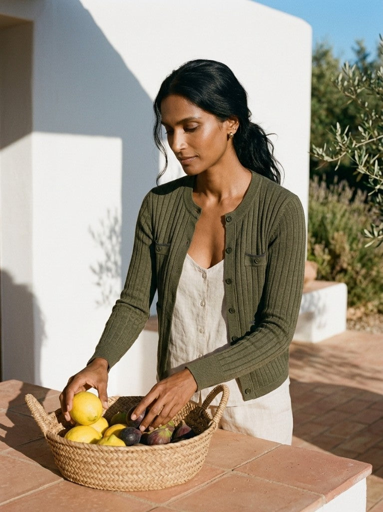Woman wearing the olive ribbed cardigan while arranging fresh fruit